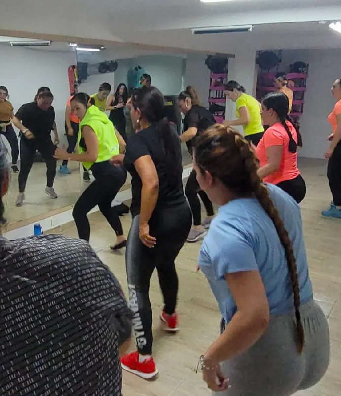 Grupo de mujeres haciendo Zumba Power para glúteos en academia virtual Danzfit Colombia