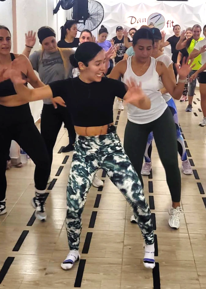 Mujer entrenando fuerza y resistencia en clase de Zumba Power con Danzfit